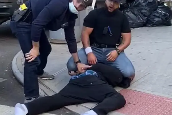 Francisco Garcia, seen in the black t-shirt and Yankees cap, kneels on a man's head after punching him during social distancing enforcement in the East Village